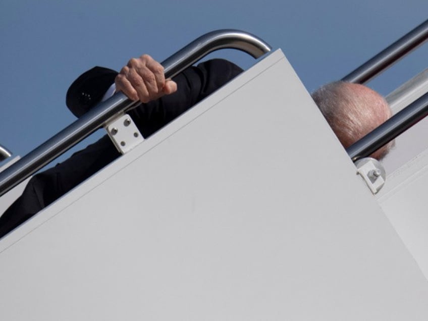 US President Joe Biden trips as he boards Air Force One at Joint Base Andrews in Maryland on March 19, 2021. - President Biden travels to Atlanta, Georgia, to tour the Centers for Disease Control and Prevention, and to meet with Georgia Asian American leaders, following the Atlanta Spa shootings. (Photo by Eric BARADAT / AFP) (Photo by ERIC BARADAT/AFP via Getty Images)