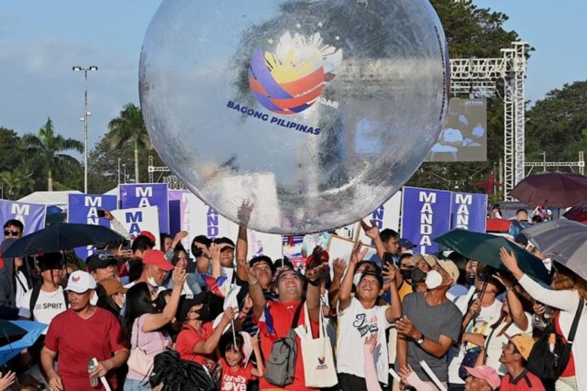 Thousands of flag-waving people massed at a seaside park in the capital Manila hours ahead of an early evening rally headlined by the president