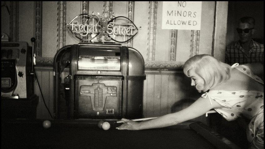 Marilyn Monroe playing pool.