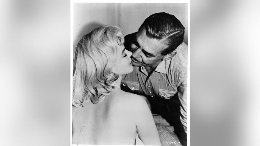 Marilyn Monroe receiving a kiss from Clark Gable