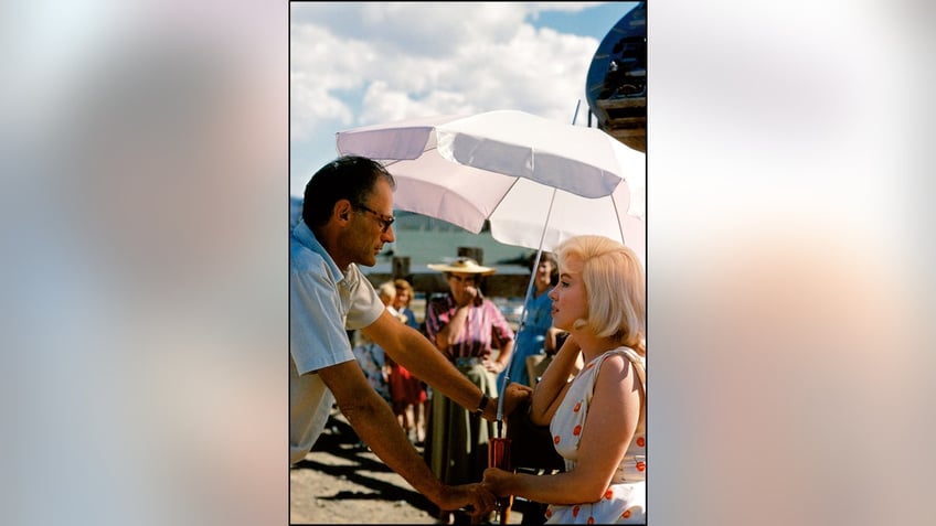 Marilyn Monroe chatting with Arthur Miller on set.