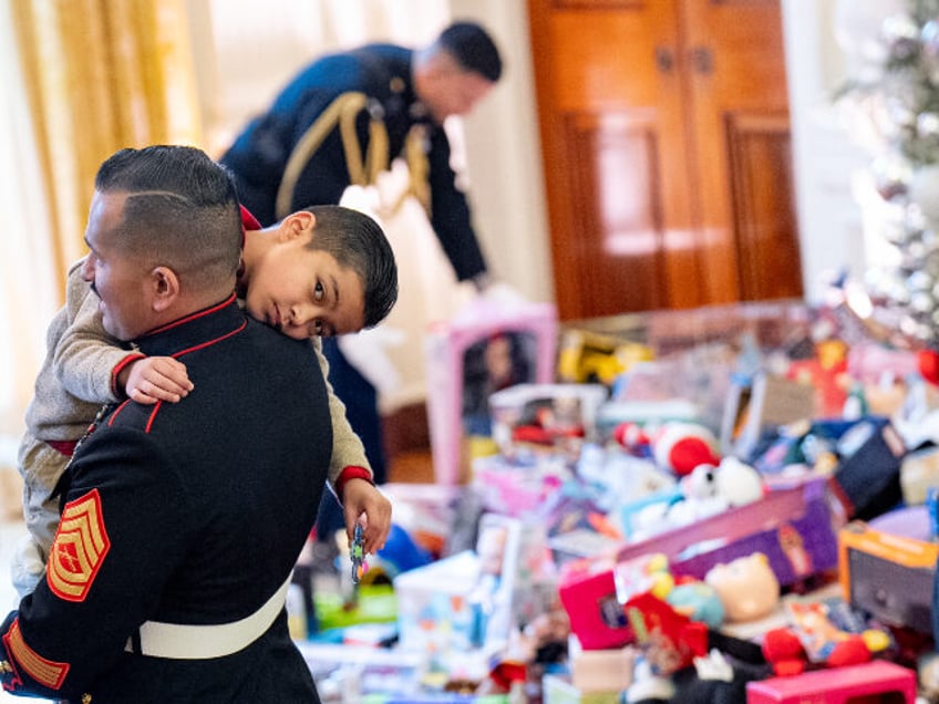 Members of the military stack up piles of toys before first lady Jill Biden arrives for a