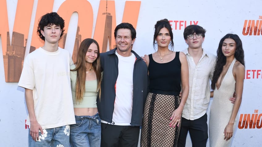 Mark Wahlberg smiles next to his wife Rhea on the carpet with his kids Brendan, Grace, Michael and his son's girlfriend Sunni