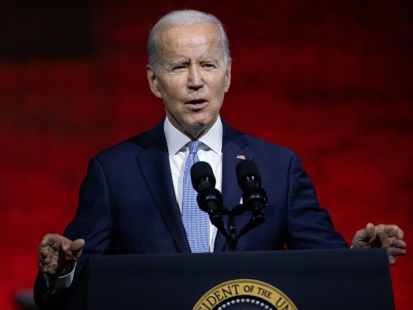 Joe Biden speaks against hell background