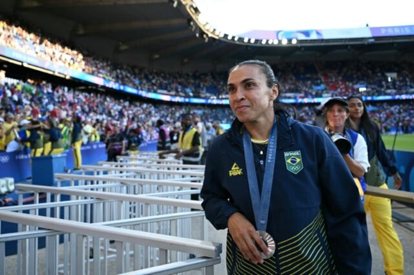 Marta poses with the Olympic silver medal after Brazil's defeat against the United States