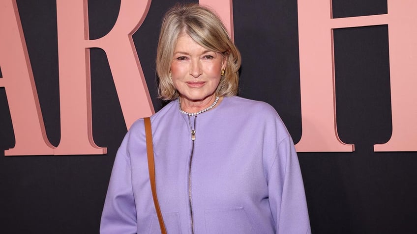 Martha Stewart in a lavender jacket soft smiles on the carpet at her documentary premiere