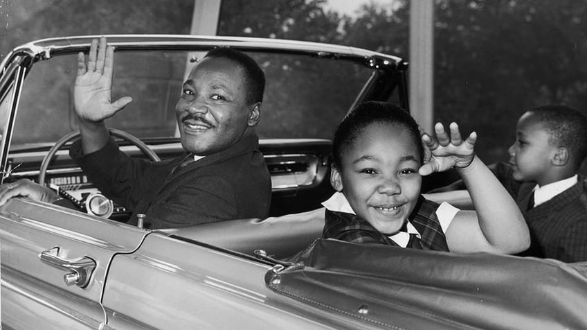 Martin Luther King Jr. and his children waving in a car