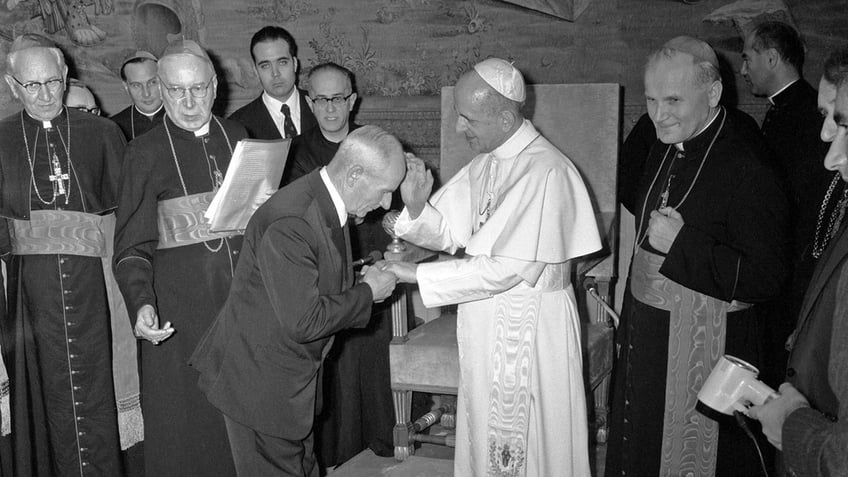 Pope Paul VI blessing Franciszek Gajowniczek. The future Pope St. John Paul II is on the far right.