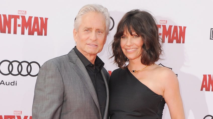 Evangeline Lilly wears black strappy dress at Ant-Man premiere with Michael Douglas.