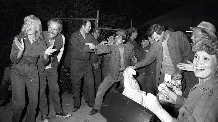 The cast of M*A*S*H celebrating the finale in a black and white photo