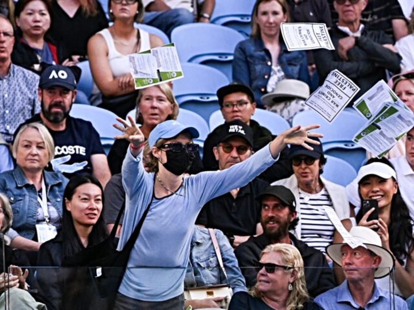 A pro-Palestinian protester throws leaflets onto the court during the men's singles match between Britain's Cameron Norrie and Germany's Alexander Zverev on day nine of the Australian Open tennis tournament in Melbourne on January 22, 2024. (Photo by WILLIAM WEST / AFP) / -- IMAGE RESTRICTED TO EDITORIAL USE - …