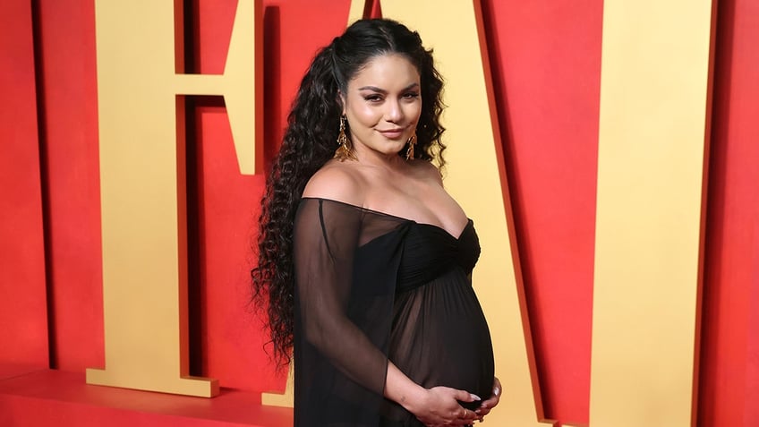 Vanessa Hudgens cradling her baby bump on the red carpet