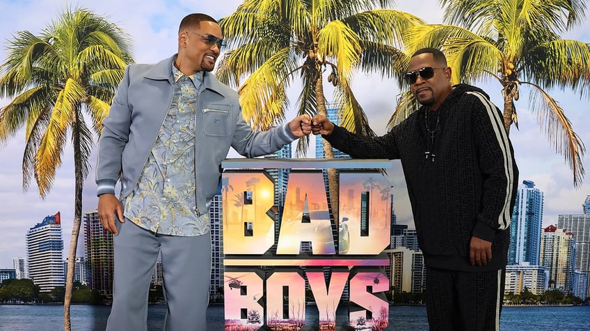 Will Smith and Martin Lawrence doing a fist bump over a Bad Boys signage