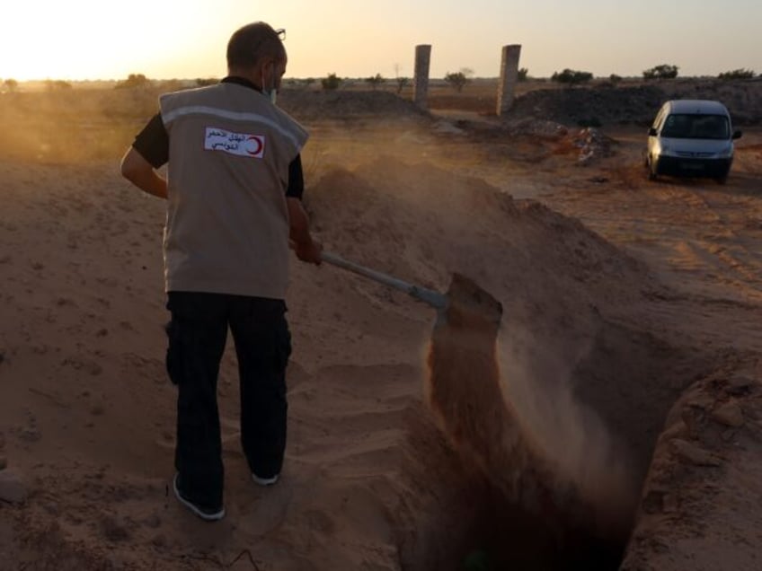 Unemployed former fisherman Chamseddine Marzouz digs a grave at a make-shift cemetary for