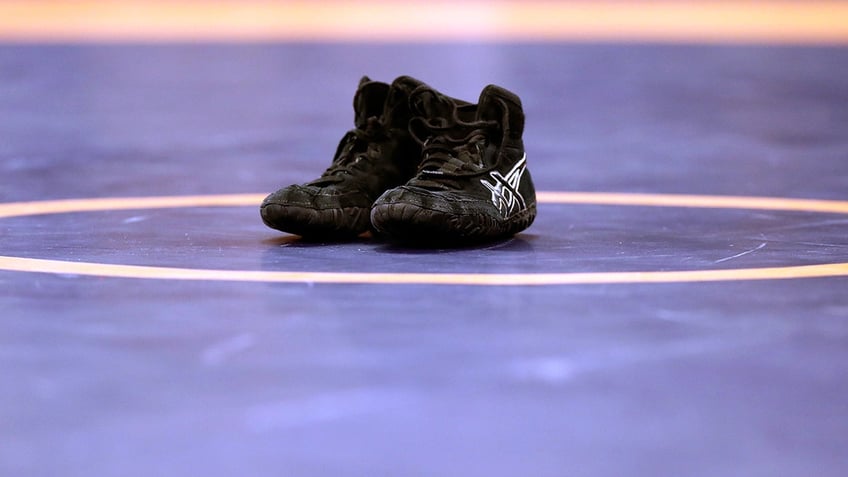 Shoes sit on wrestling mat