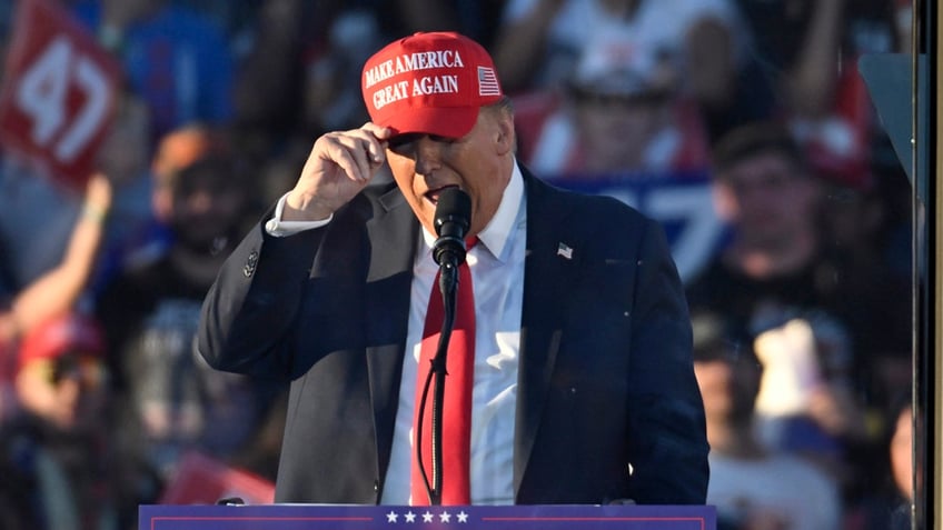 Donald Trump in red MAGA cap speaking