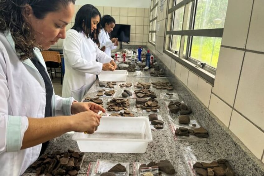 Archaeologists examine ceramic fragments found during excavations at the construction site of a complex of popular apartments in the city of Sao Luis, Brazil