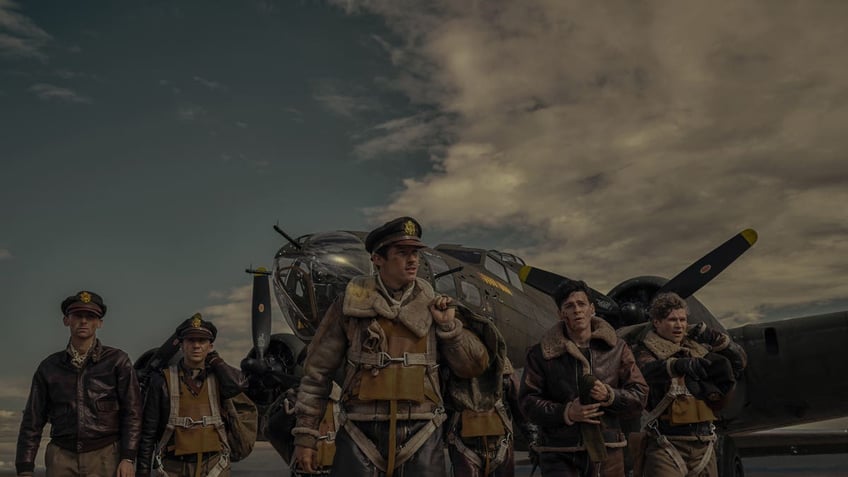 soldiers stand in front of plane in masters of the air