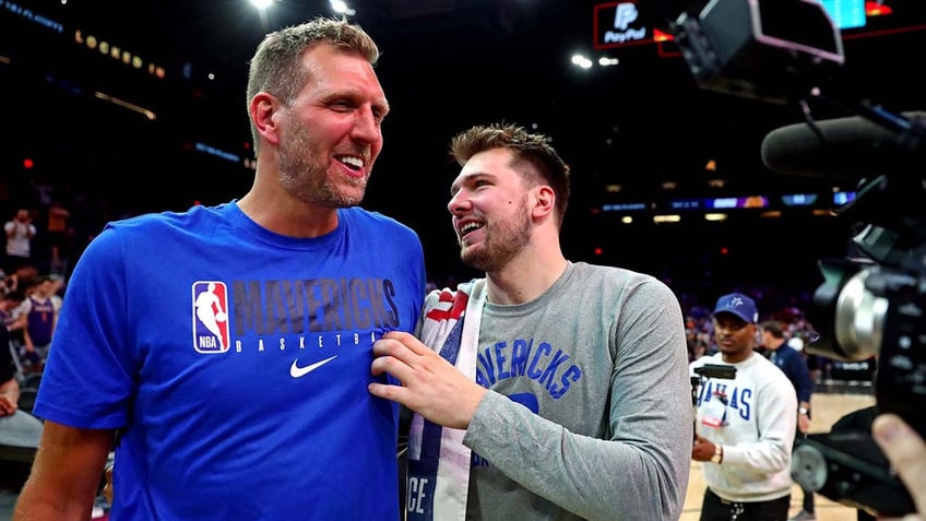 Luka Doncic interacts with Dirk Nowitzki