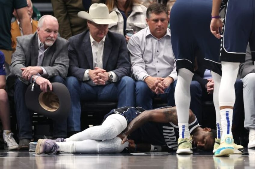 Kyrie Irving of the Dallas Mavericks lies on the court after suffering an injury in the fi