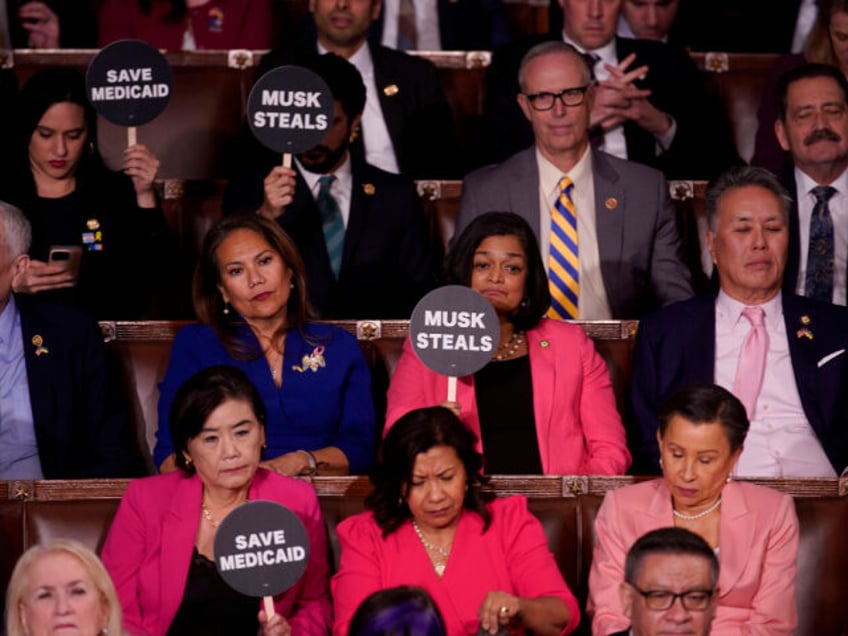 House Democrats hold signs in protest during a joint session of Congress in the House Cham