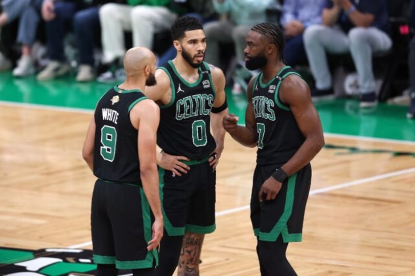 Boston's Derrick White, Jayson Tatum and Jaylen Brown huddle during the Celtics' win over