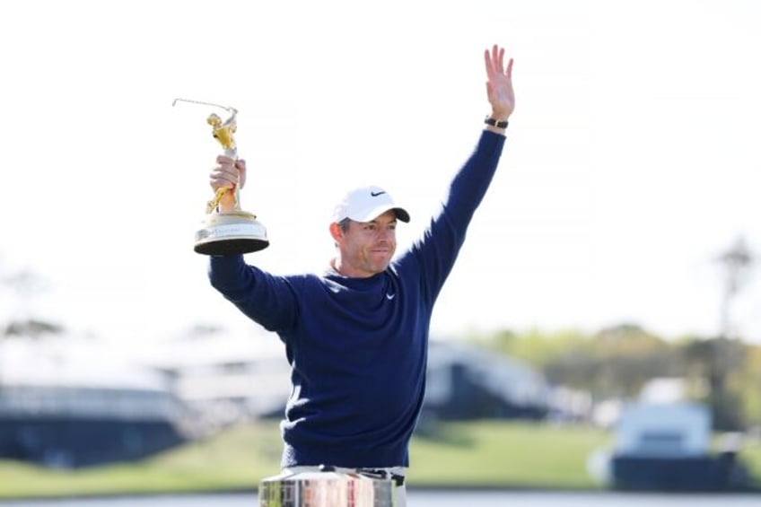 Rory McIlroy celebrates with the trophy after winning the playoff at the Players Champions