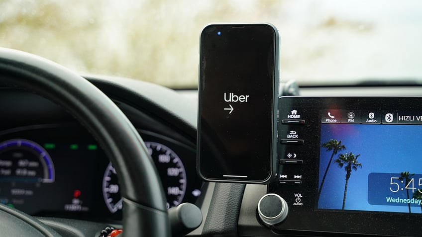uber app open on the dashboard of a car