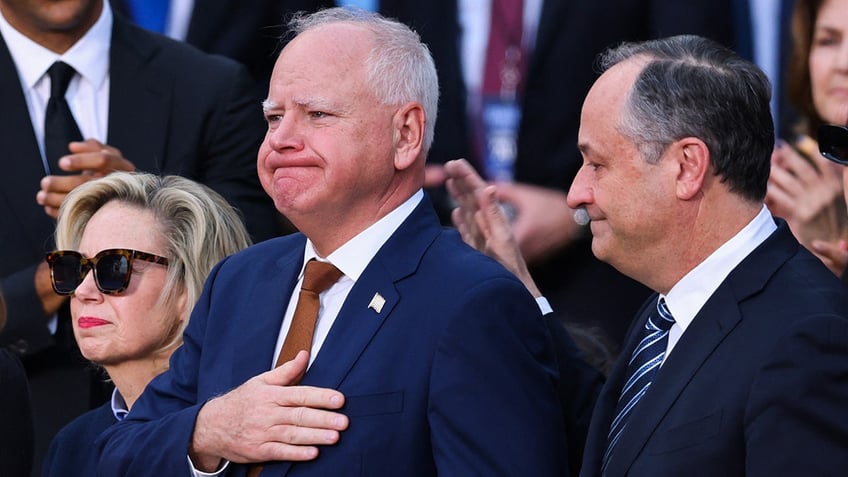 Tim Walz is comforted by second gentleman Doug Emhoff