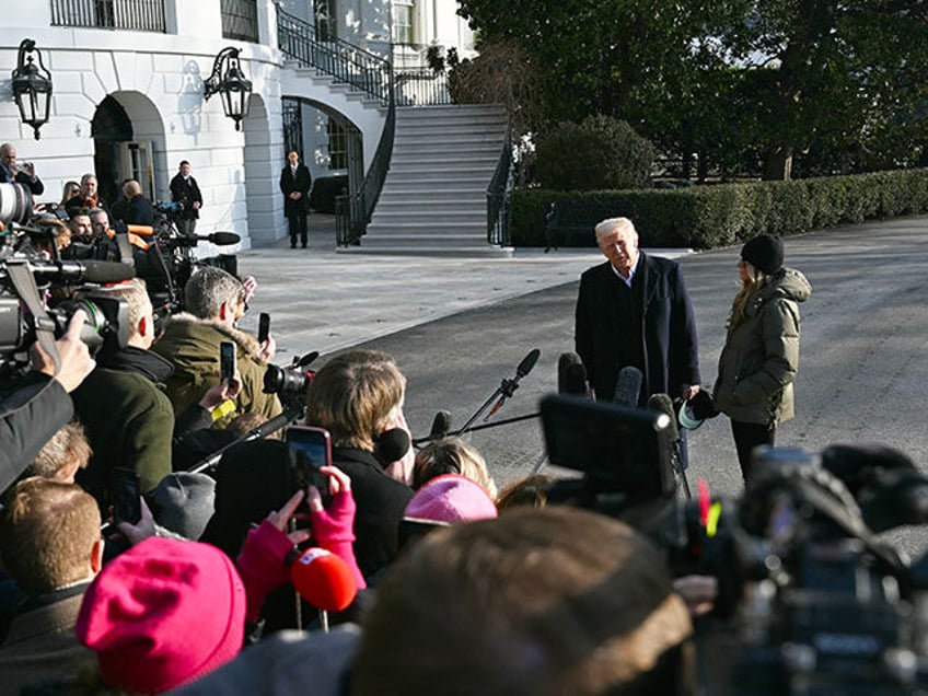 US President Donald Trump, with First Lady Melania Trump, speaks to the press before board