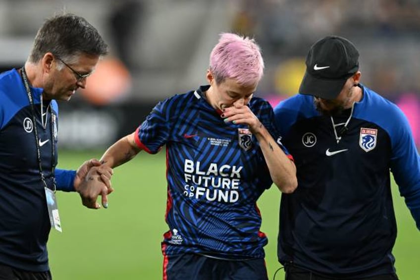 Reign's US midfielder Megan Rapinoe is helped off the pitch after an injury in the early minutes of the first half of the National Women's Soccer...