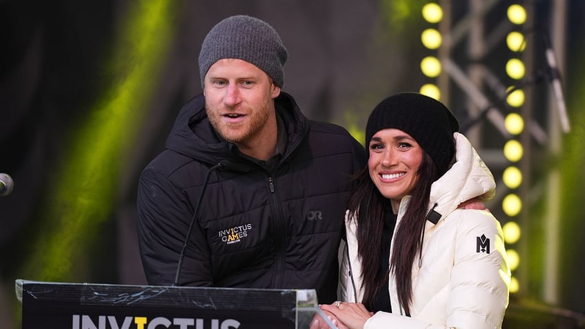 Prince Harry and Meghan Markle, bundled up and holding onto each other