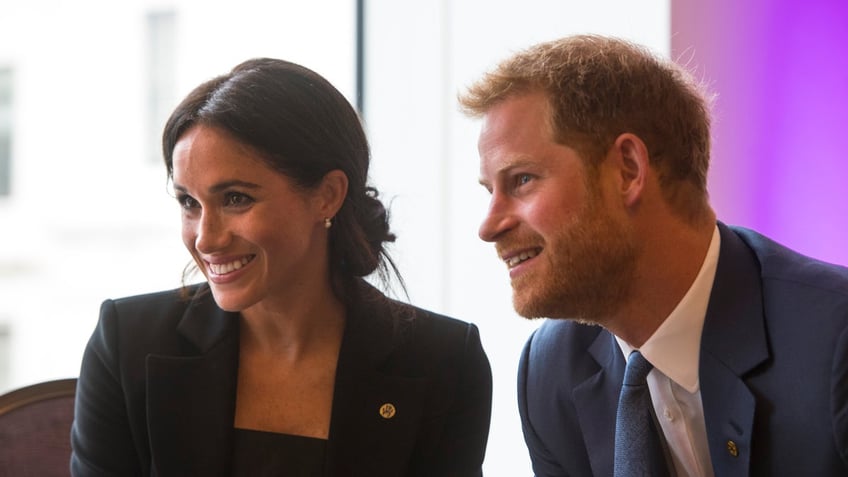 Prince Harry Meghan Markle leaning against each other and smiling