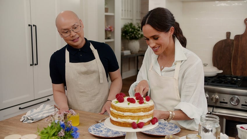 Meghan Markle fixing a cake inside a Montecito mansion as her friend watches.