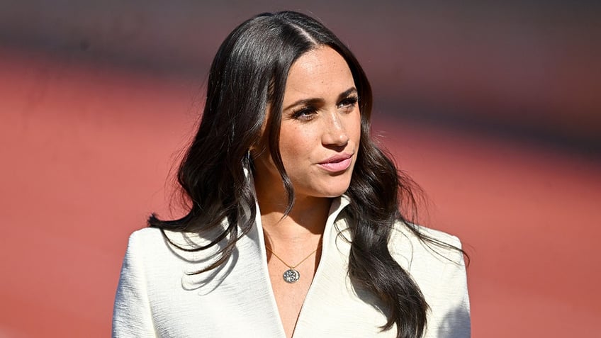 A close-up of Meghan Markle wearing a white blazer.