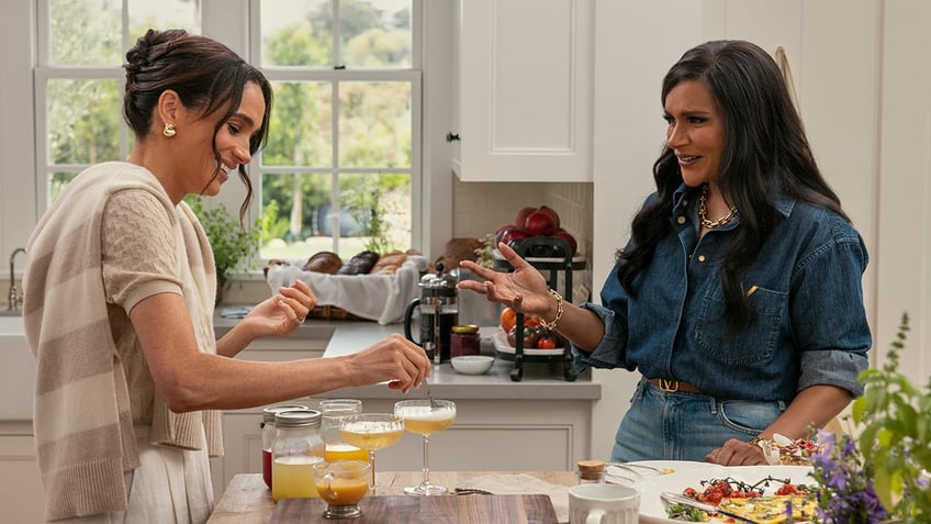 A close-up of Meghan Markle and Mindy Kaling making bellinis in the kitchen.