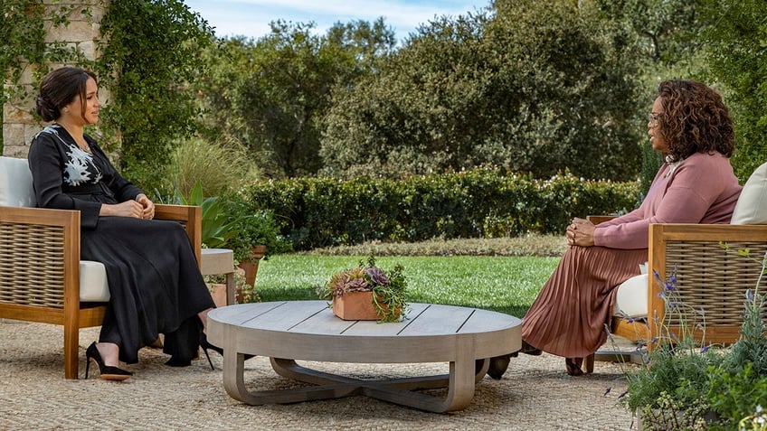 Meghan Markle being interviewed by Oprah Winfrey in an outdoors setting