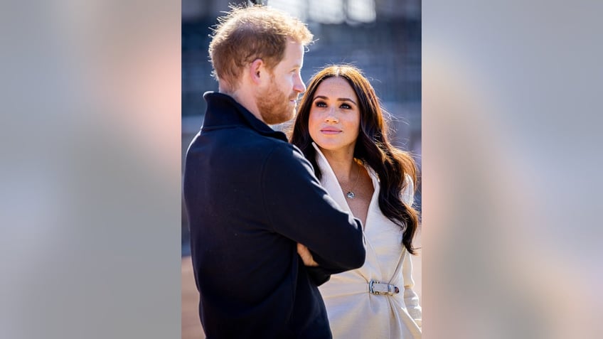 Meghan Markle looking at Prince Harry seriously as he looks ahead.