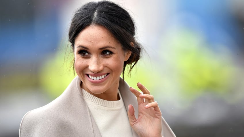 Meghan Markle in a light sand jacket waves in Ireland