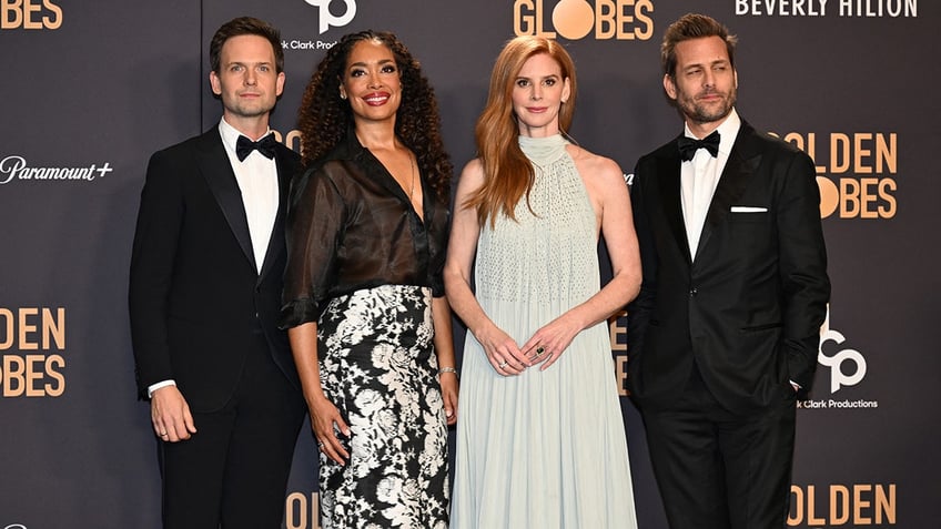The cast of Suits posing together during the Golden Globes