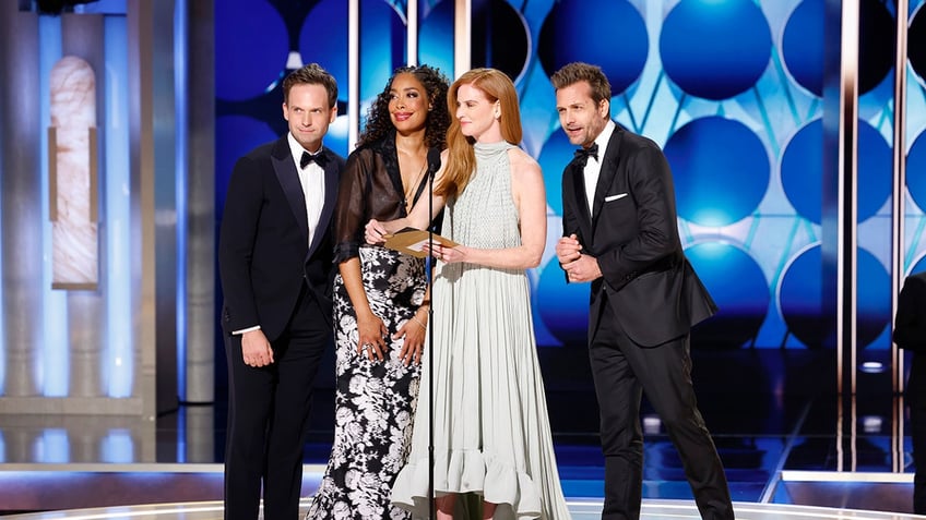 The cast of suits presenting an award at the Golden Globes