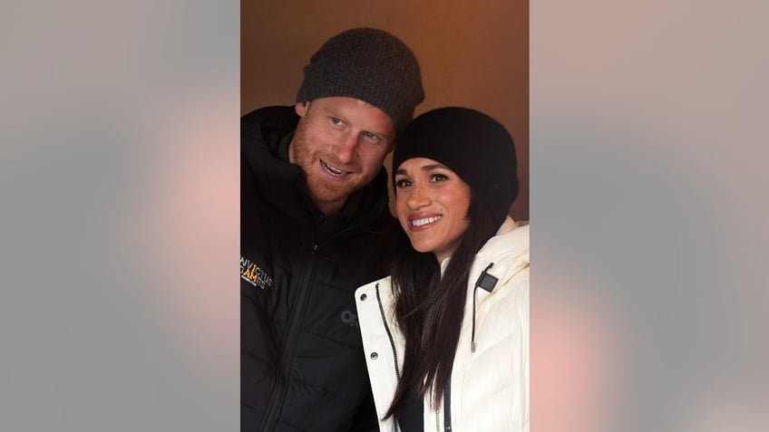 Meghan Markle and Prince Harry leaning into each other bundled up and smiling