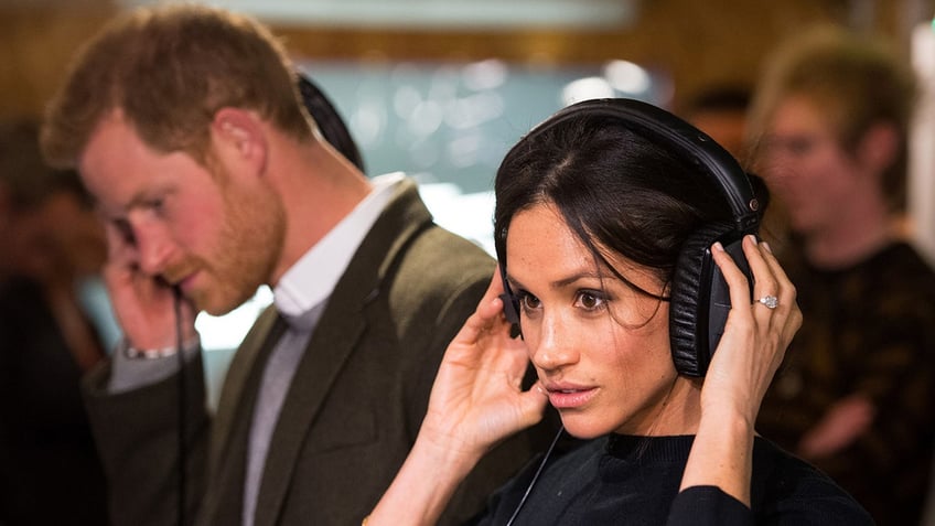 A close-up of Meghan Markle listening to headphones