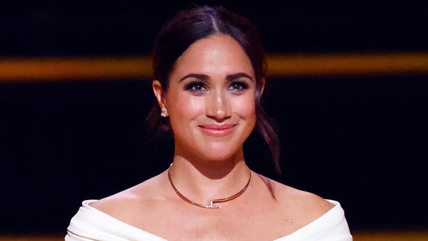 A close-up of Meghan Markle wearing a white blouse
