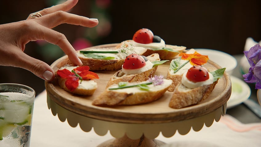 A close-up of Meghan Markle serving finger foods.