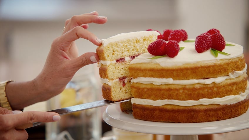 Meghan Markle's hands serving a slice of cake.