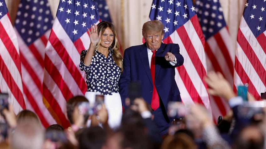 Former President Donald Trump stands onstage with his wife, former first lady Melania Trump, after announcing that he will once again run for U.S. president