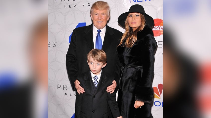 NEW YORK, NY - NOVEMBER 30: Donald Trump (L) and Melania Trump (R) and son Barron (C) attend Rockefeller Center Christmas Tree Lighting Party at Rock Center Cafe on November 30, 2011 in New York City.