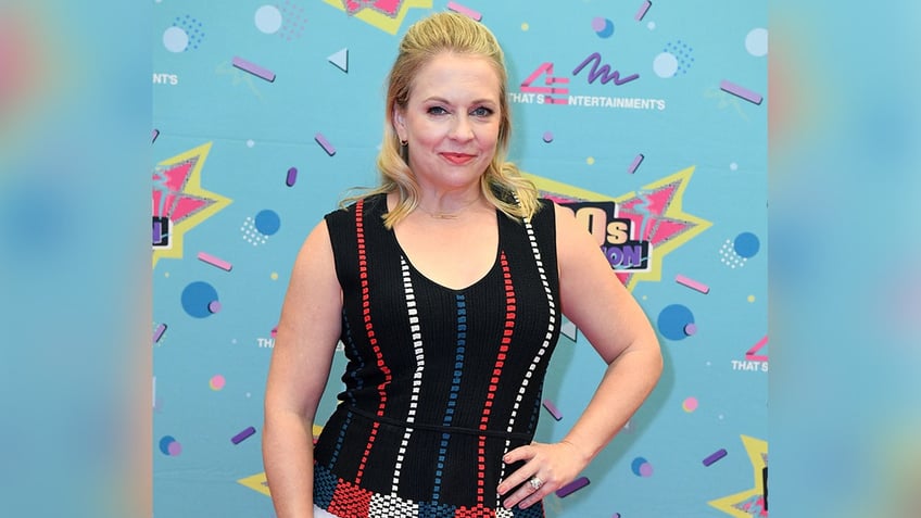 Melissa Joan Hart puts her hand on her hip in a black top at 90s con