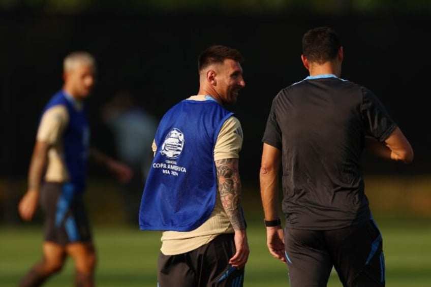 Lionel Messi (C) talks with Argentina head coach Lionel Scaloni (R)